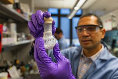 Person holiding up chemical mixture in a beaker 
