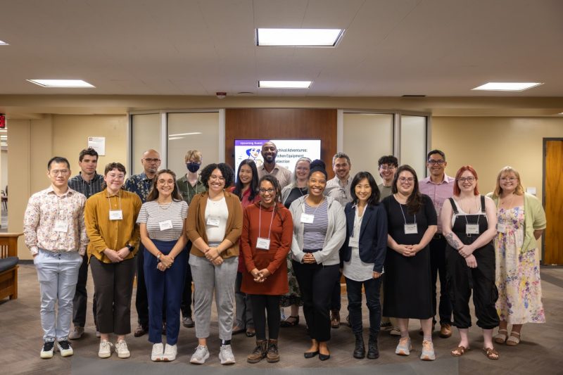 A group of smiling early-career librarians stand together for a picture.