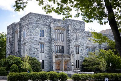 An early fall scene of the outside of Newman Library with students walking.