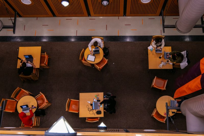 An above view of students studying at round tables.