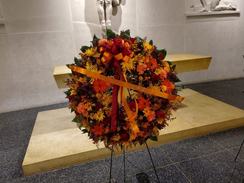 An orange and maroon wreath with Mary Lucado's name on it was placed in the War Memorial Chapel.