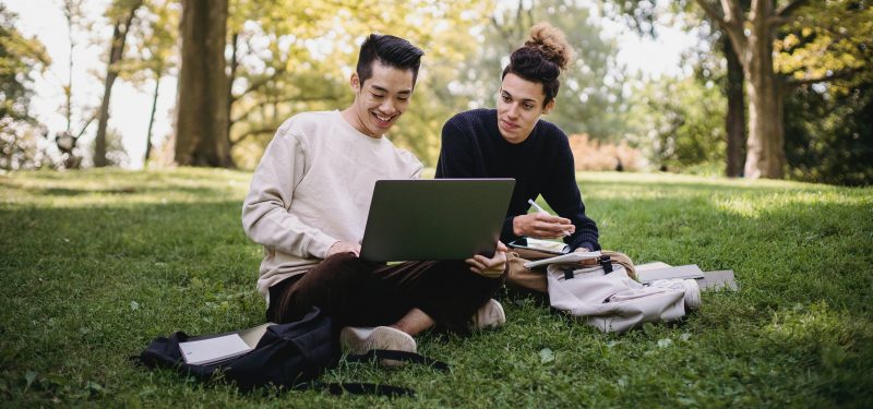 Two persons looking at a laptop