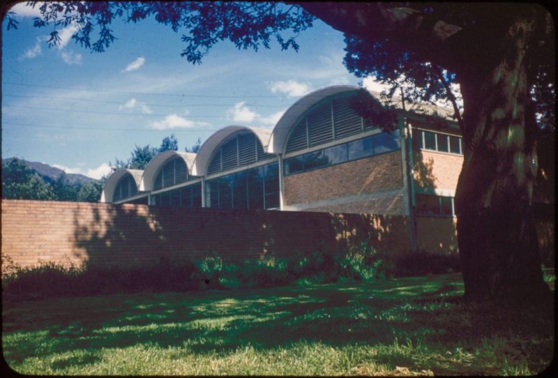 A large building complex with four horizontal cylindrical shapes that make up the roof.