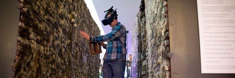 Library patron walking through the Vauquois Exhibit wearing a virtual reality headset.